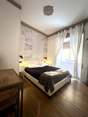 a bedroom with a bed and a table and a window at Rome Eternal City in Rome