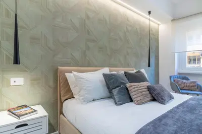 a bedroom with a bed with white pillows and a wall at Cyprus - Roma's Delightful Lodges in Rome