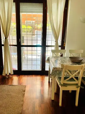 a dining room with a table and chairs and sliding doors at Appartamento luminoso con giardino in Rome