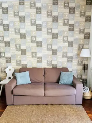 a brown couch in a living room with a wall at Appartamento luminoso con giardino in Rome