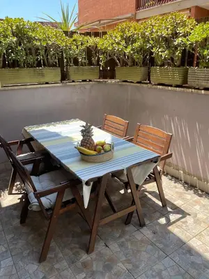 a table and chairs with a bowl of fruit on it at Appartamento luminoso con giardino in Rome