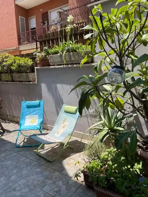 two blue chairs sitting on a patio with plants at Appartamento luminoso con giardino in Rome