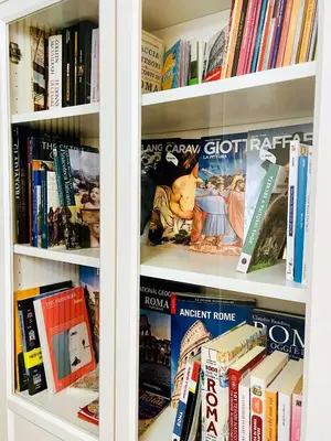 a book shelf filled with lots of books at Appartamento luminoso con giardino in Rome