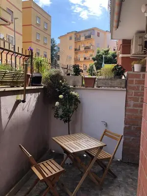 two chairs and a table on a small balcony at Appartamento luminoso con giardino in Rome