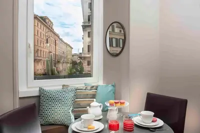 a table with cups and plates on it in a room with a window at Corso Vittorio 308 in Rome