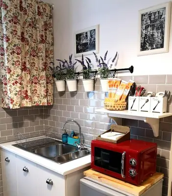 a kitchen with a sink and a red microwave at La Chiave di Roma in Rome