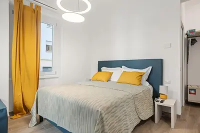 a bedroom with a large bed with yellow pillows at Urban Loft - San Giovanni by RHR in Rome