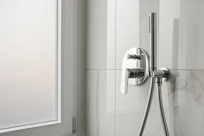 a shower head in a bathroom next to a window at Urban Loft - San Giovanni by RHR in Rome