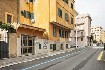 an empty street with a yellow building on the side at Urban Loft - San Giovanni by RHR in Rome