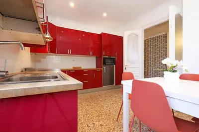 a red kitchen with a sink and a table at LCGrandTour Donatello in Rome