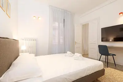 a bedroom with a bed and a desk and a chair at LCGrandTour Donatello in Rome