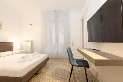 a bedroom with a bed and a desk and a chair at LCGrandTour Donatello in Rome