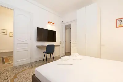 a bedroom with a bed and a desk and a television at LCGrandTour Donatello in Rome
