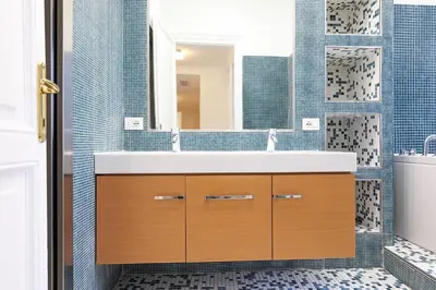a bathroom with a sink and blue tiles at LCGrandTour Donatello in Rome
