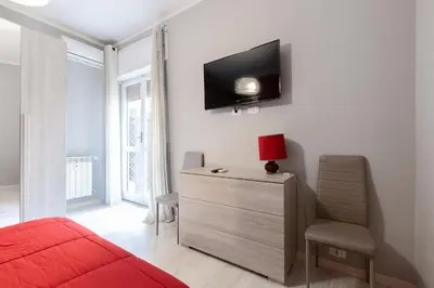 a bedroom with a red bed and a tv on the wall at Affittacamere Alpino 76 in Rome