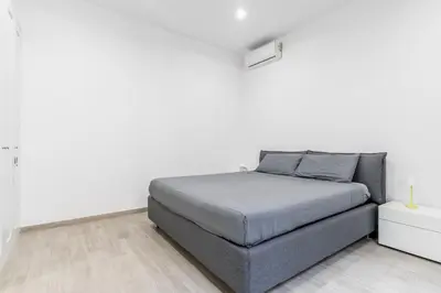a white bedroom with a bed and a white wall at The Trastevere Apartment in Rome