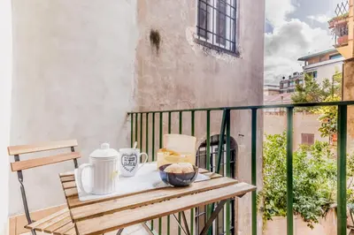 a table on a balcony with a tea kettle and a bowl of food at The Trastevere Apartment in Rome