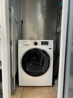 a white washing machine sitting in a room at The Trastevere Apartment in Rome