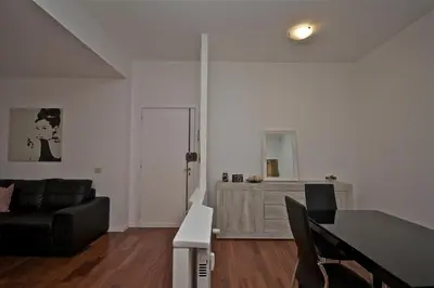 a living room with a black couch and a table at PORTA PORTESE apartment in Rome