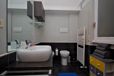 a bathroom with a white sink and a toilet at PORTA PORTESE apartment in Rome