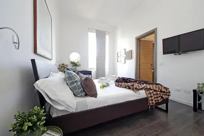 a bedroom with a bed with white sheets and pillows at St Peter Giant Apartment in Rome