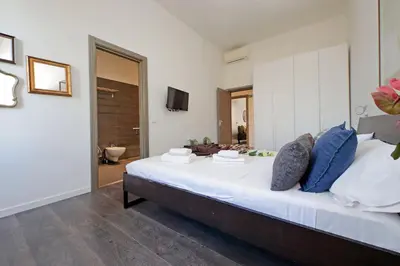 a bedroom with a large white bed with blue pillows at St Peter Giant Apartment in Rome