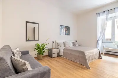 a white living room with a bed and a couch at ARGILLA PLACE Large apartment close to Saint Peter Basilica in Rome