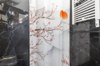 a bathroom with a shower curtain with a flower pattern at ARGILLA PLACE Large apartment close to Saint Peter Basilica in Rome