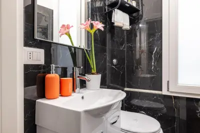 a bathroom with a white toilet and a sink at ARGILLA PLACE Large apartment close to Saint Peter Basilica in Rome