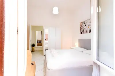 a white bedroom with two beds and a mirror at Elegantis Giolitti Suite Apartment with Private Balcony in Rome