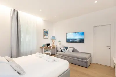 a white room with a bed and a couch at ARIOSTO'S Luxury Rooms in Rome
