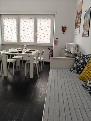 a dining room with a table and chairs and two windows at Gregorio VII Dream House in Rome