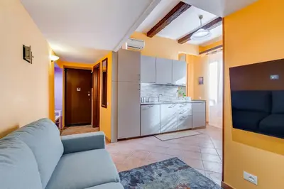 a living room with a couch and a kitchen at Casa Garbha in Rome