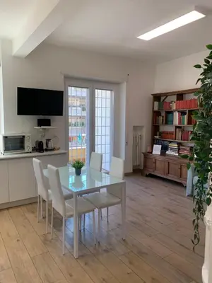 a dining room with a glass table and white chairs at Annalisa Home in Rome