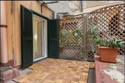 a balcony with green doors and a wooden floor at Barberini Exclusive Apartment in Rome