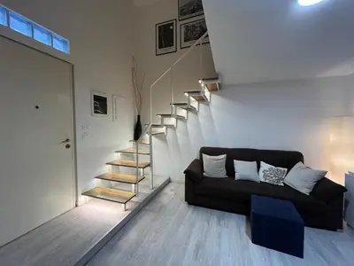 a living room with a couch and a staircase at LaDolcevita - Casa Milvia in Rome