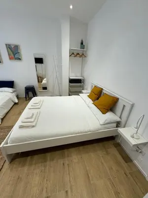 a bedroom with a large white bed with yellow pillows at Suite San Giovanni in Rome