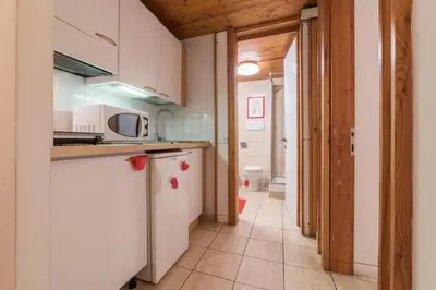 a kitchen with white cabinets and a sink and a toilet at Romeathome146 - Monti in Rome