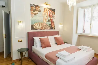 a bedroom with a painting on the wall and a bed at Golden Palace Luxury Guest House in Rome