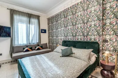 a bedroom with a green bed and a floral wall at Emily in Rome in Rome