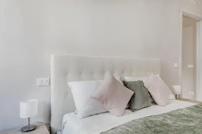 a white bedroom with a bed with pillows at Biancaapartment in Rome