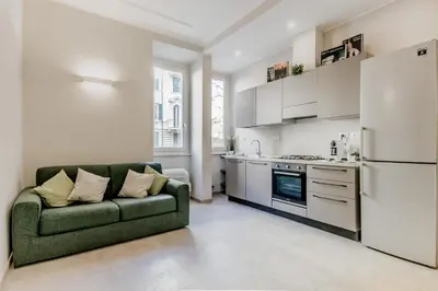 a living room with a green couch and a kitchen at Biancaapartment in Rome