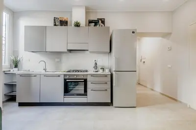 a kitchen with white cabinets and a refrigerator at Biancaapartment in Rome