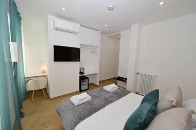 a bedroom with a bed and a tv and a couch at Relais Trastevere Station in Rome