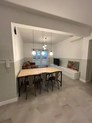 a dining room and living room with a table and chairs at Casa Roma Metro B Tiburtina in Rome