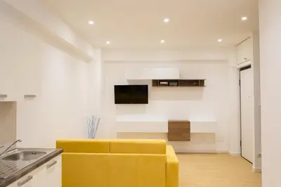 a living room with a yellow couch in a kitchen at RoomApartment Roma in Rome