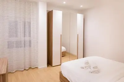 a white room with a bed and a window at RoomApartment Roma in Rome
