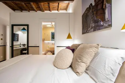 a bedroom with a white bed with two pillows at Pantheon Suites Rome 1 in Rome