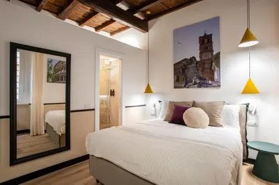 a bedroom with a large bed and a mirror at Pantheon Suites Rome 1 in Rome