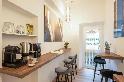a kitchen with a counter with a coffee maker and stools at Pantheon Suites Rome 1 in Rome